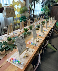 a long table is set up with place cards and succulents on it