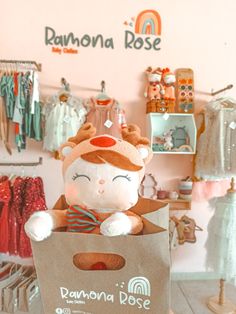 a stuffed animal in a paper bag with clothes on the wall behind it and a sign that says ramon rose