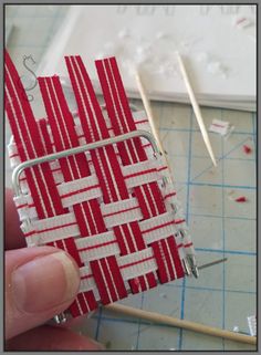 someone is working on something with red and white strips attached to the back of a piece of fabric