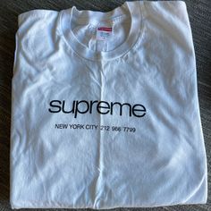 Released Alongside Several Other Tees As A Part Of Supreme's Ss20 Week One Drop, The Shop Tee Is Sure To Become An Instant Classic Tee Design. The Tee Features The Word Supreme Above The Words "New York" And A Phone Number And Released In Eight Colorways. Size Large. Never Worn Classic White Shirt With Graphic Print, Classic White Shirt With Letter Print, Classic Spring Tops With Letter Print, Classic Streetwear Tops For Spring, Classic Spring Streetwear Tops, Classic Tops For Spring Streetwear, Classic Logo Print Tops For Spring, Trendy White Shirt With Branding, Classic White Tops With Branding