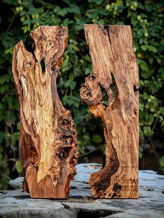 two pieces of wood sitting on top of a rock