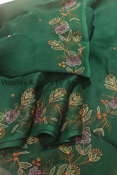 green and pink floral embroidered fabric with gold thread work on the border, two pieces are laying next to each other