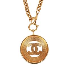 This vintage 1980's necklace features a large classic CC medallion with a sunburst design, long rolo chain and a springring/hook closure in 24K gold plated metal. Origin: France Condition: Vintage; Excellent - this necklace shows mild signs of wear, including light scratching, pitting, and some darkening near the chain links. Accompanied by: Chanel box Measurements: 16" chain, 2.25" x 2.25" pendant Gold Chain Necklace With Gold-tone Logo, Gold Chain Necklace With Logo Plaque, Gold Metal Necklaces With Gold-tone Logo Plaque, Metal Pendant Jewelry With Gold-tone Logo Plaque, Metal Pendant Necklace With Gold-tone Logo Plaque, Luxury Gold Chain Necklace With Logo Plaque, Luxury Gold Chain Necklace With Logo, Vintage Gold Necklace With Gold-tone Logo Plaque, Vintage Jewelry With Gold-tone Logo Plaque