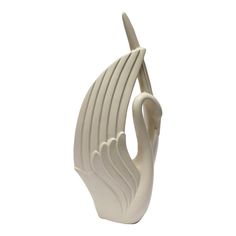 a white ceramic bird sculpture on a white background