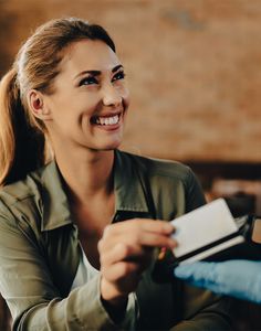 a woman is smiling and holding a credit card