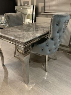 a marble top table with two blue chairs