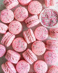 pink sprinkle covered cookies and cupcakes on a table