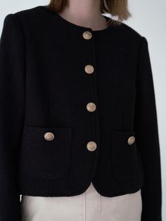 This is a tweed jacket with a round neckline, offering a modern twist on classic outerwear. It's designed with a button-down front, featuring prominent buttons that stand out against the fabric. The jacket has two patch pockets at the front, providing both function and a decorative element. The material gives the impression of a knit texture, which suggests that it's intended for warmth and comfort.- The round neckline provides a soft, feminine touch and allows for various underlayering options.- The buttons add a contrasting detail that enhances the jacket's visual appeal.- The jacket's cropped length makes it an ideal piece for pairing with high-waisted bottoms or over dresses. Winter Office Tweed Jacket With Buttons, Classic Black Tweed Jacket With Button Closure, Winter Workwear Tweed Jacket With Buttons, Fall Tweed Jacket With Buttoned Pockets For Work, Winter Office Tweed Jacket With Button Cuffs, Classic Black Tweed Jacket With Buttons, Classic Wool Blazer With Buttoned Pockets, Tweed Jacket With Buttoned Pockets For Work, Black Tweed Blazer With Buttons