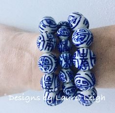 Blue & White Chinoiserie Longevity BraceletThis chunky Blue & White Chinoiserie Longevity Bracelet is a Designs by Laurel Leigh original design. Blue & White Chinoiserie Longevity Bracelets are made with beautiful large blue and white porcelain longevity symbol beads. Bracelets are made with beautiful large blue and white porcelain longevity symbol beads. Shown with regular size beaded bracelet for size reference. Other bracelet(s) pictured sold separately. Other items pictured are sold separate Blue 108 Beads Bracelet Jewelry, Blue Spiritual Stretch Bracelet With Large Beads, Blue Stretch Bracelet With Large Beads, Spiritual Blue Stretch Bracelet With Large Beads, Traditional Hand-wrapped Blue Bracelets, Traditional Blue Bracelet With Large Beads, Blue Hand Wrapped Beaded Bracelets, Blue Stretch Bracelet With Large Round Beads, Blue Spiritual Bracelets With Large Beads