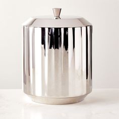 a stainless steel canister sitting on top of a white counter