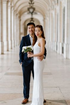 a bride and groom pose for a wedding photo in the hallway of an old building