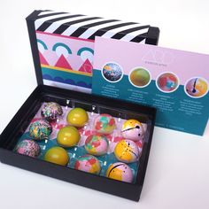 a box filled with lots of different colored decorated easter eggs next to a greeting card