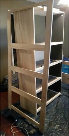 a tall wooden shelf with shelves on top of it in the process of being built