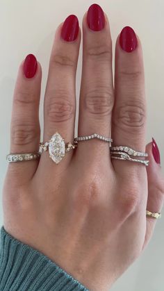 a woman's hand with three different rings on her fingers and one is wearing a ring