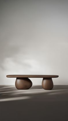 an oval table with two wooden bases in the shape of three circles, on a gray background