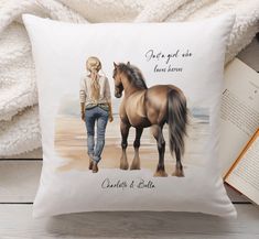 there is a pillow with a horse on it and an open book next to it