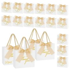 small white gift bags with gold bows and happy new year tags