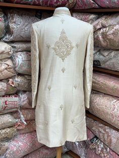 This beige white royal sherwani is brought into limelight with fine jaal embroidered coat enhanced with resham, pearl ,stone & cut dana work. The coat is styled with matching churidar pants. Size:40,42,44 Occasion: Wedding Ceremony or Reception WASH CARE INSTRUCTIONS - Please Dry clean only when it is applicable. Slight color variation is possible due to digital photography. Ready to Ship! Off White Traditional Wear With Dabka For Designer Occasions, Bollywood Sherwani With Chikankari Embroidery For Eid, Long Sleeve Raw Silk Sherwani With Chikankari Embroidery, Cream Sherwani With Chikankari Embroidery And Long Sleeves, Fitted Off White Kurta With Naqshi, Off White Naqshi Sherwani For Diwali, Diwali Raw Silk Sherwani With Chikankari Embroidery, Cream Long Sleeve Sherwani With Chikankari Embroidery, Bollywood Sherwani With Chikankari Embroidery