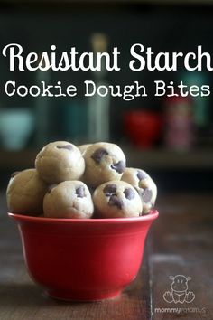 a red bowl filled with cookies on top of a wooden table