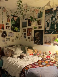 a bedroom with pictures on the wall and stuffed animals on the bed in front of it