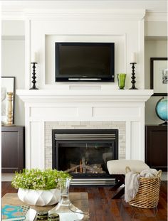 a living room filled with furniture and a flat screen tv mounted above a fire place