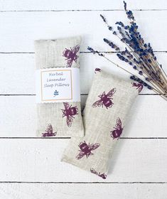 two napkins with bees on them sitting next to some dried flowers and a stick of lavender