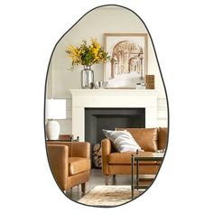 an oval mirror reflecting a living room with couches and a fireplace in the background