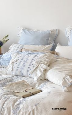 an unmade bed with blue and white linens