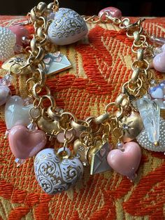 a close up of a bracelet with hearts and charms