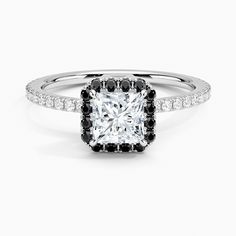 a square cut diamond with black and white diamonds on the band, set in 18k white gold