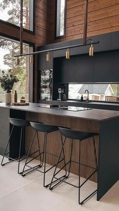 a kitchen with two bar stools next to an open window and wooden paneling