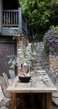 an outdoor dining table with chairs around it