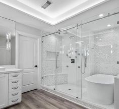 a white bathroom with a tub, sink and shower