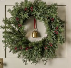 a christmas wreath with a bell hanging from it