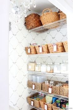 the pantry shelves have baskets and containers on them