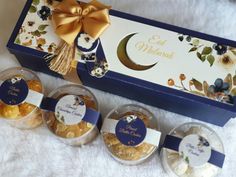 three small glass bowls filled with food sitting next to a blue box and gold ribbon