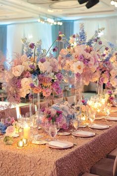 a long table with flowers and candles on it