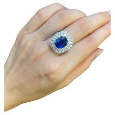 a woman's hand with a blue and white diamond ring