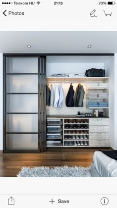 an open closet with clothes and shoes on shelves next to a white bed in a room