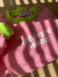 Check out our super fun pink crewneck with eye-catching neon neckline and sleeve details! Featuring a white puff print that says 'Heaven Made,' this cozy and stylish crewneck is perfect for making a statement.  Materials & Fit: -Fit is slightly cropped (wearing a size S). -50% polyester, 50% cotton -Check our size guide in the photos section to double-check your correct sizing. Care Instructions: -Non-chlorine: bleach as needed; Machine wash: cold, gentle cycle. -We advise against tumble-drying Pink Letter Print Sweatshirt For Loungewear, Pink Crew Neck Top With Letter Print, Trendy Pink Crew Sweatshirt, Trendy Pink Crew Neck Sweatshirt, Trendy Pink Sweatshirt With Relaxed Fit, Trendy Pink Relaxed Fit Sweatshirt, Trendy Relaxed Fit Pink Sweatshirt, Pink Sweatshirt With Text Print For Spring, Pink Text Print Sweatshirt For Loungewear