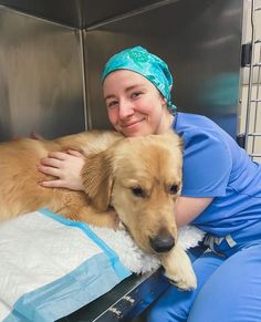 a woman in scrubs is hugging a dog