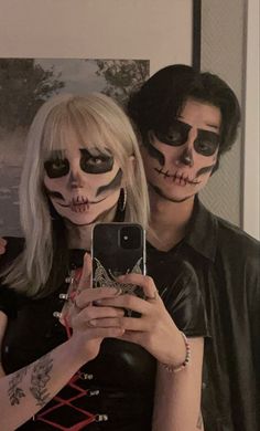 a man and woman with makeup on taking a selfie in front of a mirror