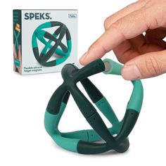 a hand is holding a green object in front of a box with the word speks on it