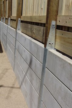 a row of wooden fence posts on the side of a building with wood slats