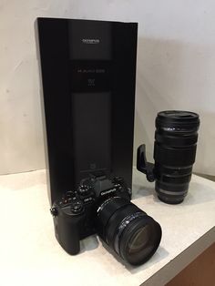 a camera and lens sitting on top of a table next to a large black box