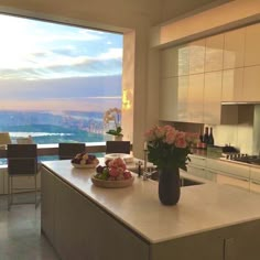 a kitchen with a large window overlooking the city and mountains is shown in this image