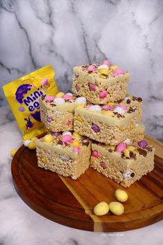 some kind of cake sitting on top of a wooden board next to a bag of candy