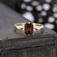 a brown and white diamond ring sitting on top of a wooden table