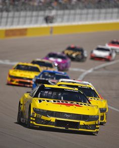 a group of cars driving down a race track