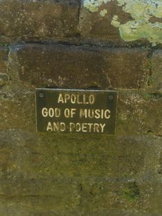 a sign on the side of a brick wall that says, apollo god of music and poetry